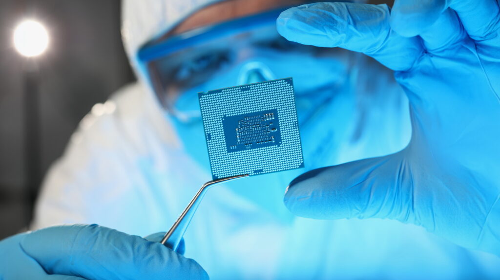 Scientist developer in protective suit holds microcircuit - Lambda Biologics Scientist developer in protective suit holds microcircuit