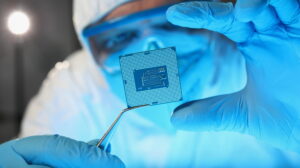 Scientist developer in protective suit holds microcircuit