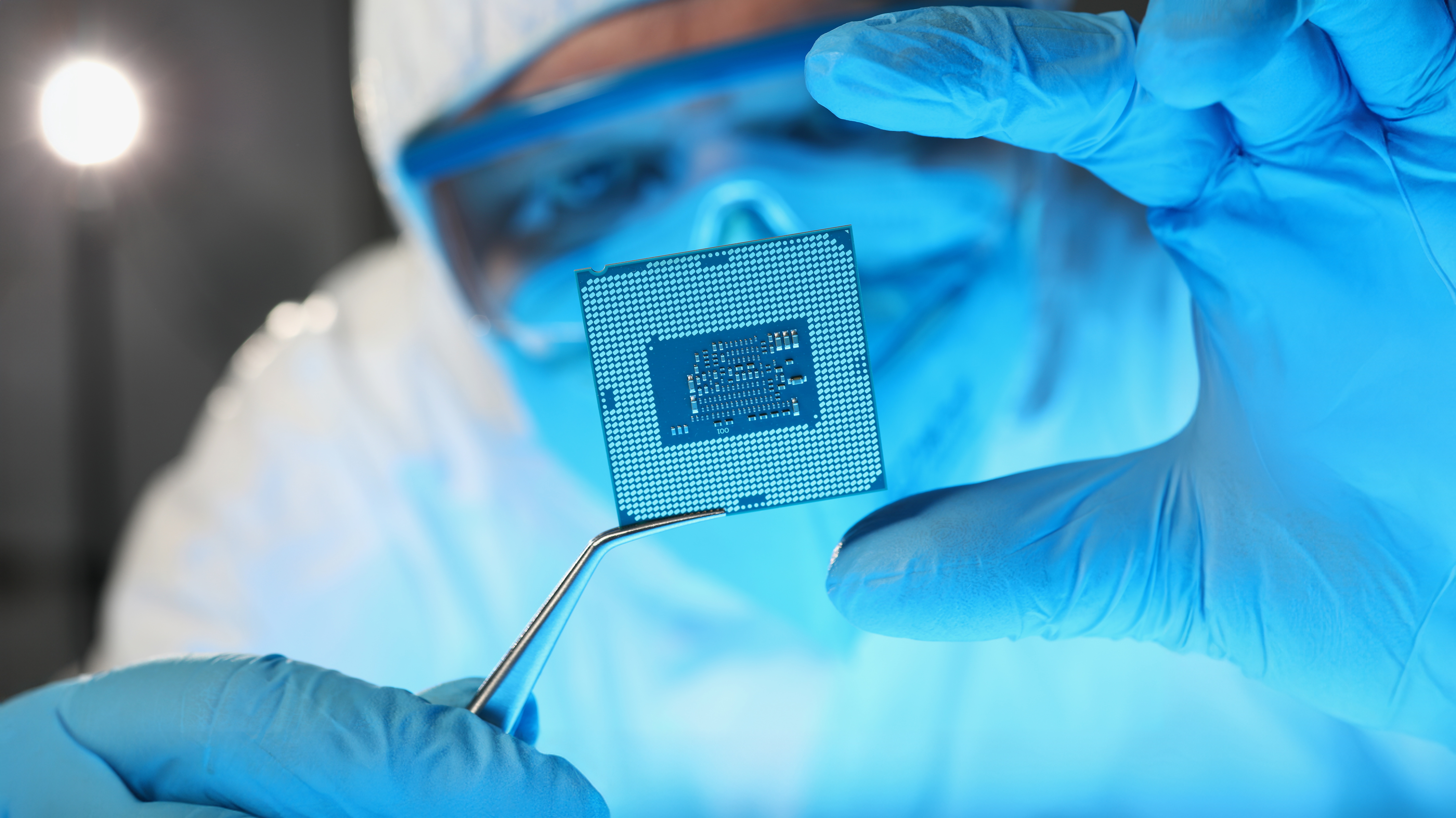 Scientist developer in protective suit holds microcircuit