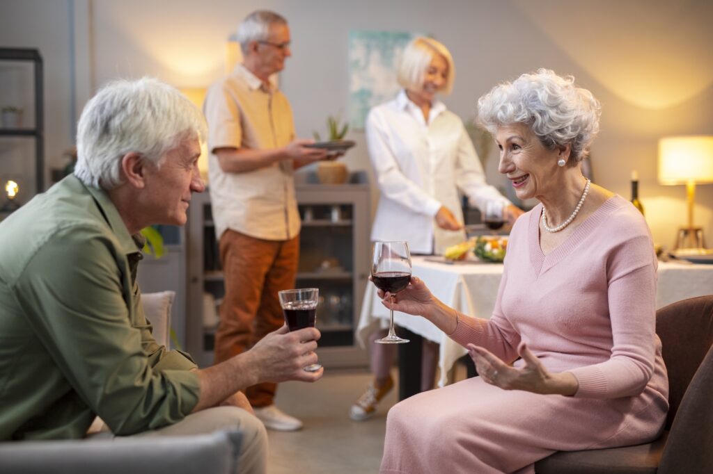 seniorfriendshavingpartynight Lambda Biologics Lambda Biologics Two elderly friends share a toast with glasses of red wine at a cozy home gathering